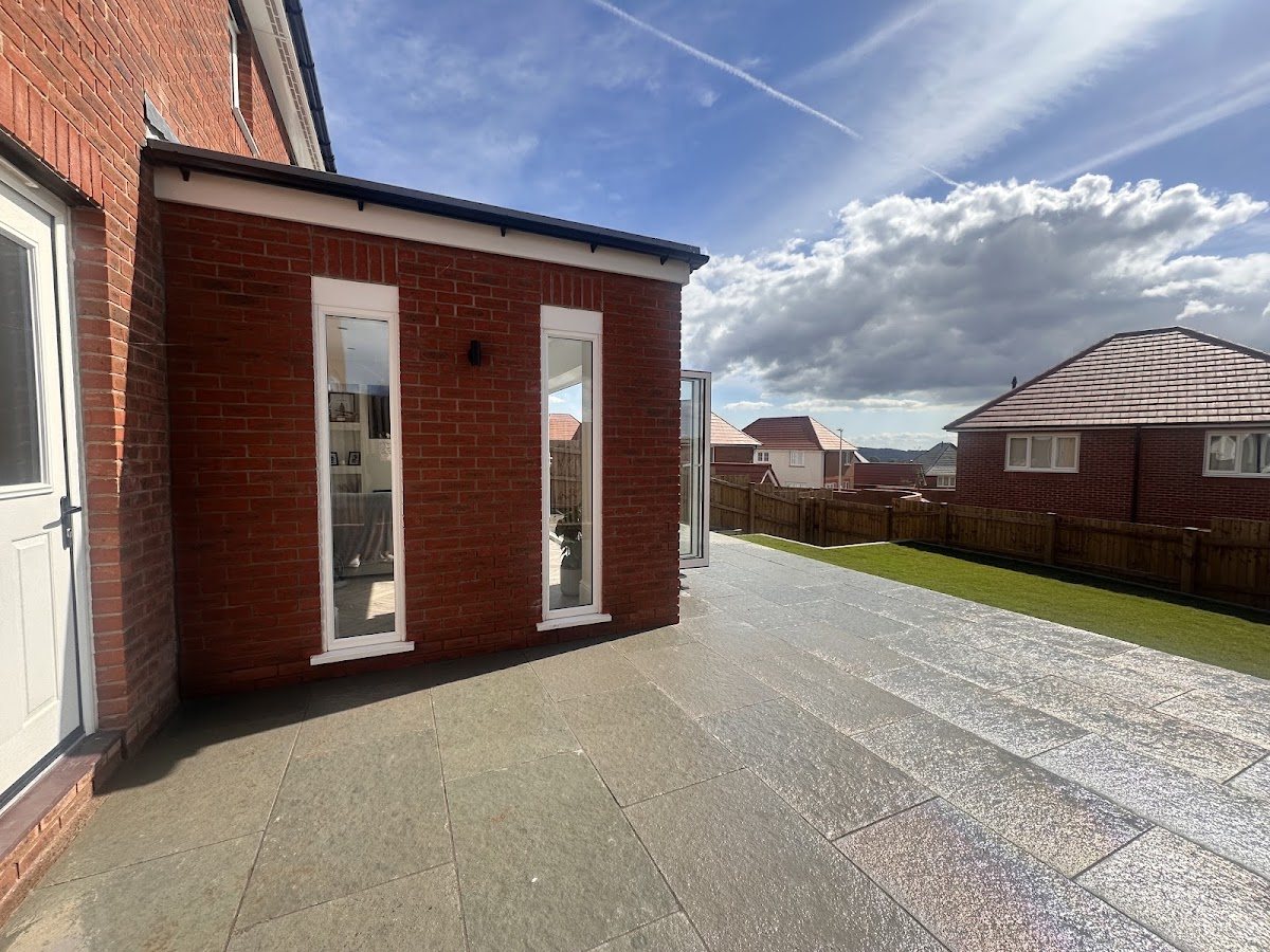 A completed landscaping project with patio, garden room and fencing